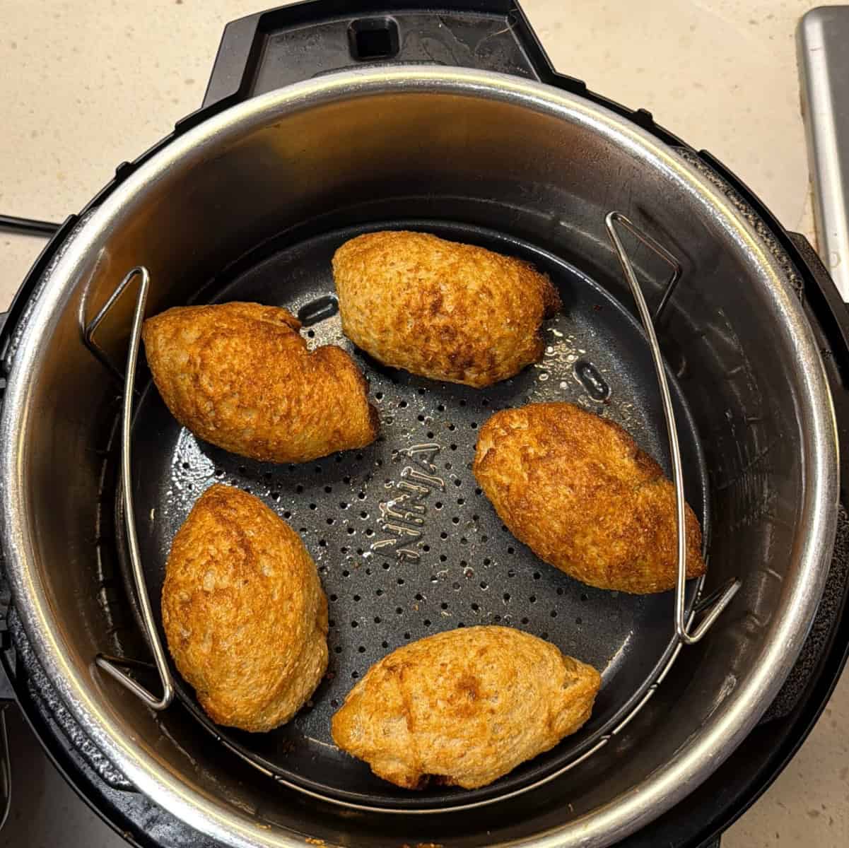 Crispy golden air fryer stuffed bread rolls after cooking