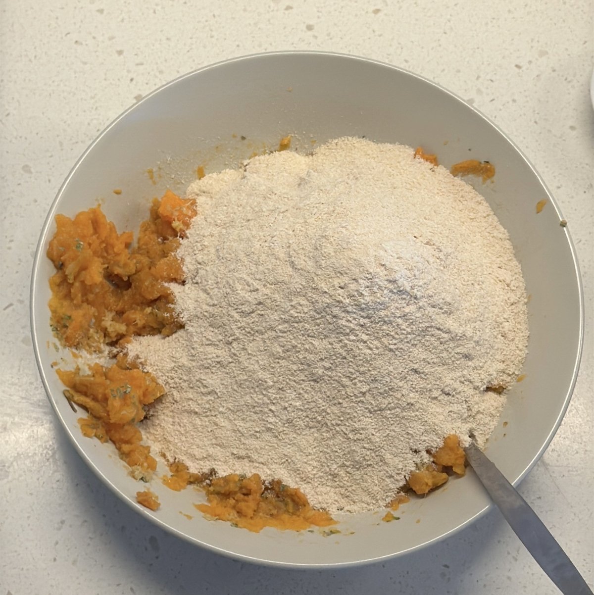 Amaranth flour added over mashed sweet potato in a bowl