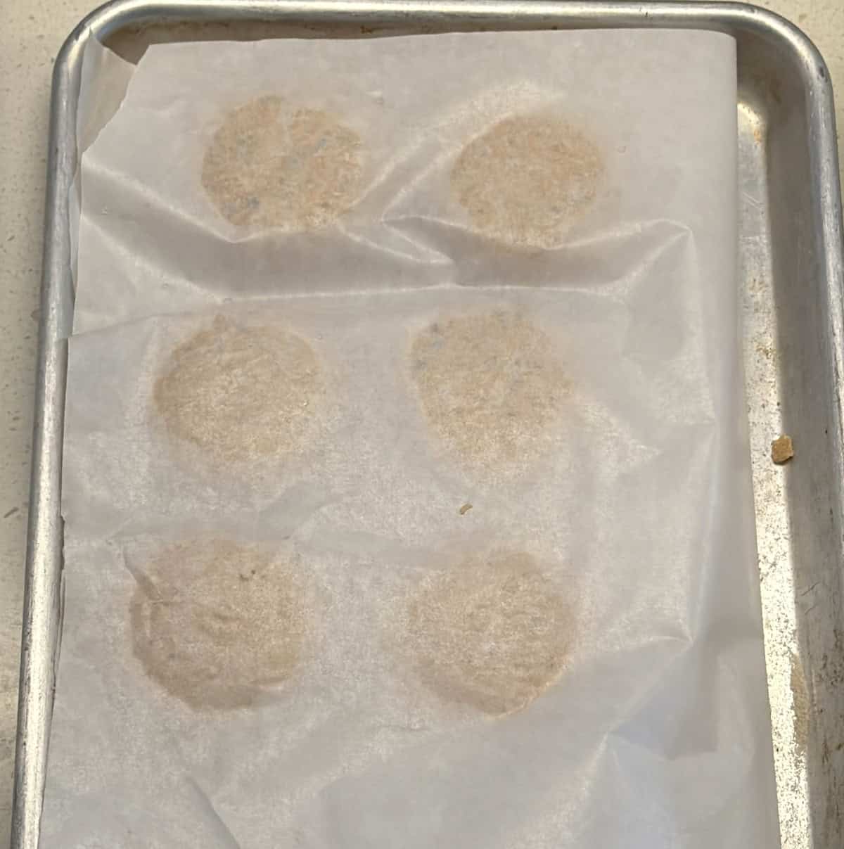 Raw amaranth patties arranged on parchment paper.
