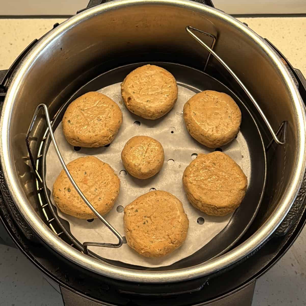 Uncooked amaranth cutlets arranged in an air fryer basket