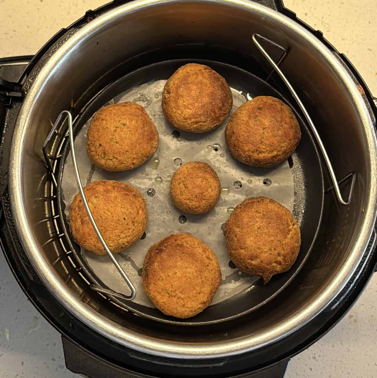 Air-fried amaranth cutlets golden brown inside an air fryer basket
