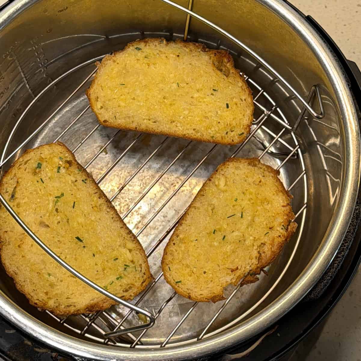 Toasted bread topped with cheese and chopped bell peppers in air fryer