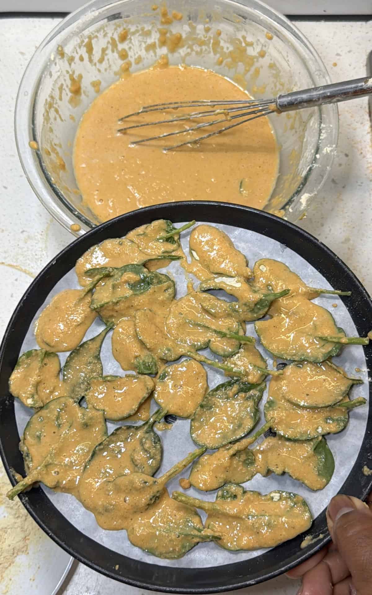 Dust spinach leaves lightly with dry flour, dip each leaf into prepared batter, coat evenly