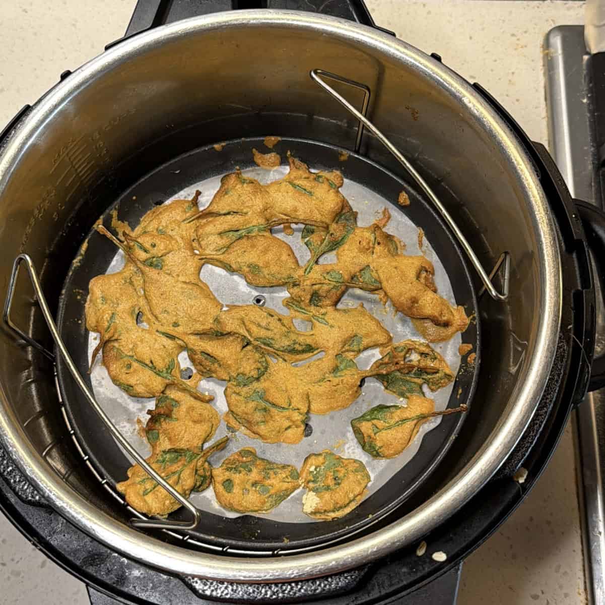 Insert tray into air fryer basket, cook spinach leaves at 180°C for 6–7 minutes until batter sets