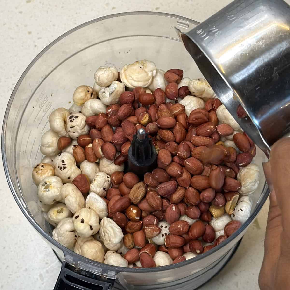 Add roasted makhana and roasted peanuts to a food processor, pulse to a coarse texture.