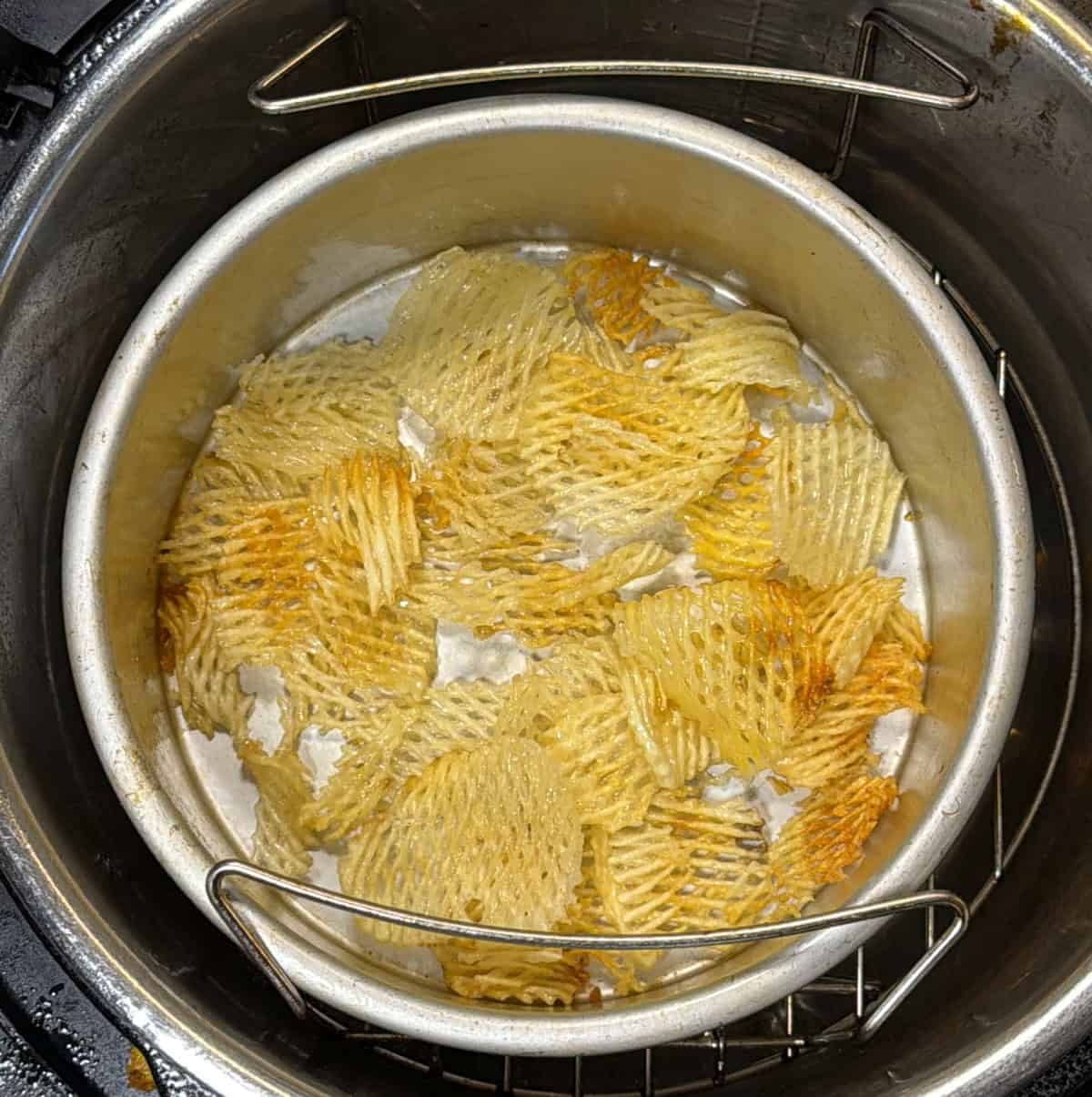 Potato chips in air fryer basket for dry fruit chivda recipe