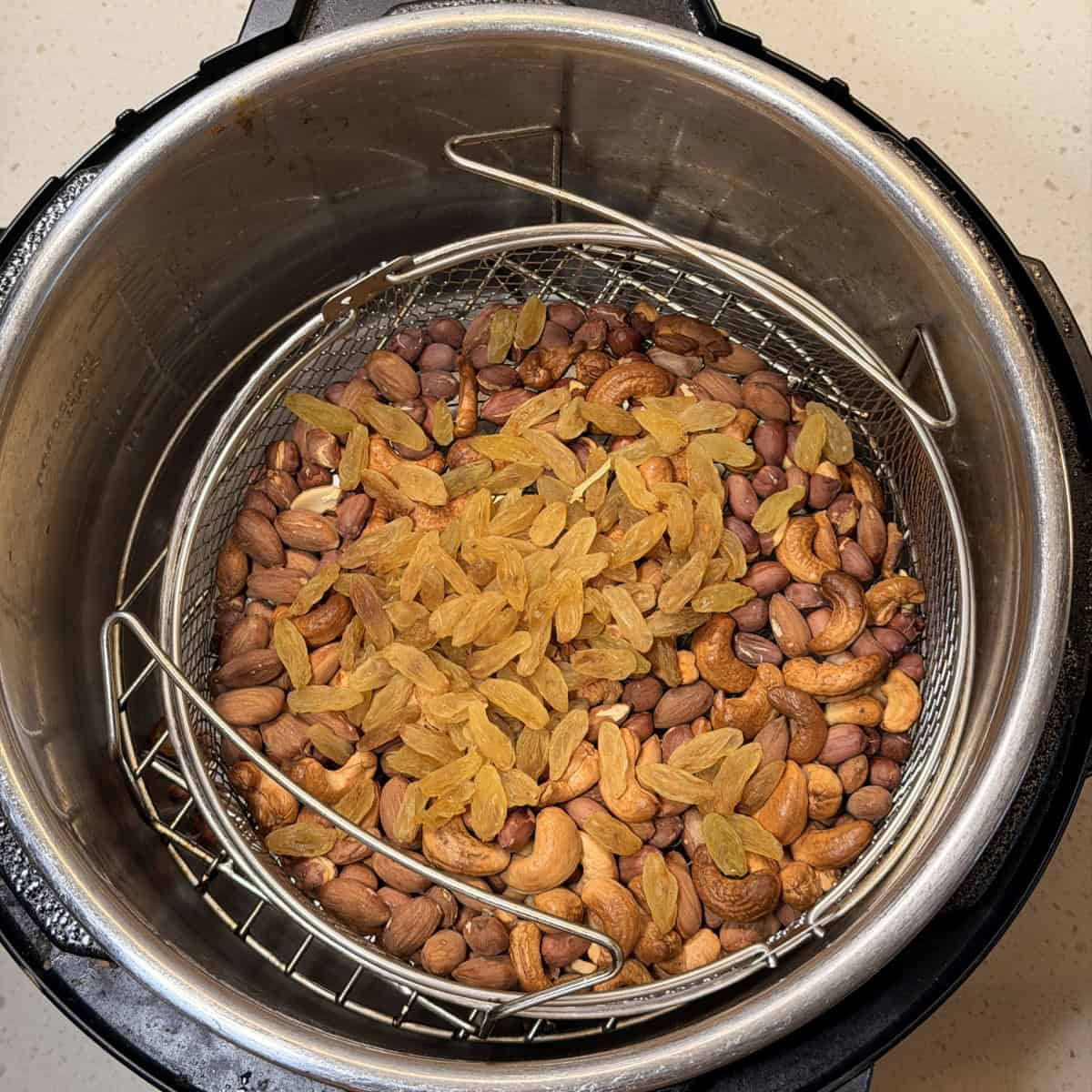 Raisins added to roasted nuts for dry fruit chivda recipe