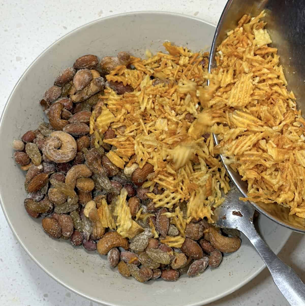 Dry fruit chivda mixed with potato chips, nuts, raisins, and spices