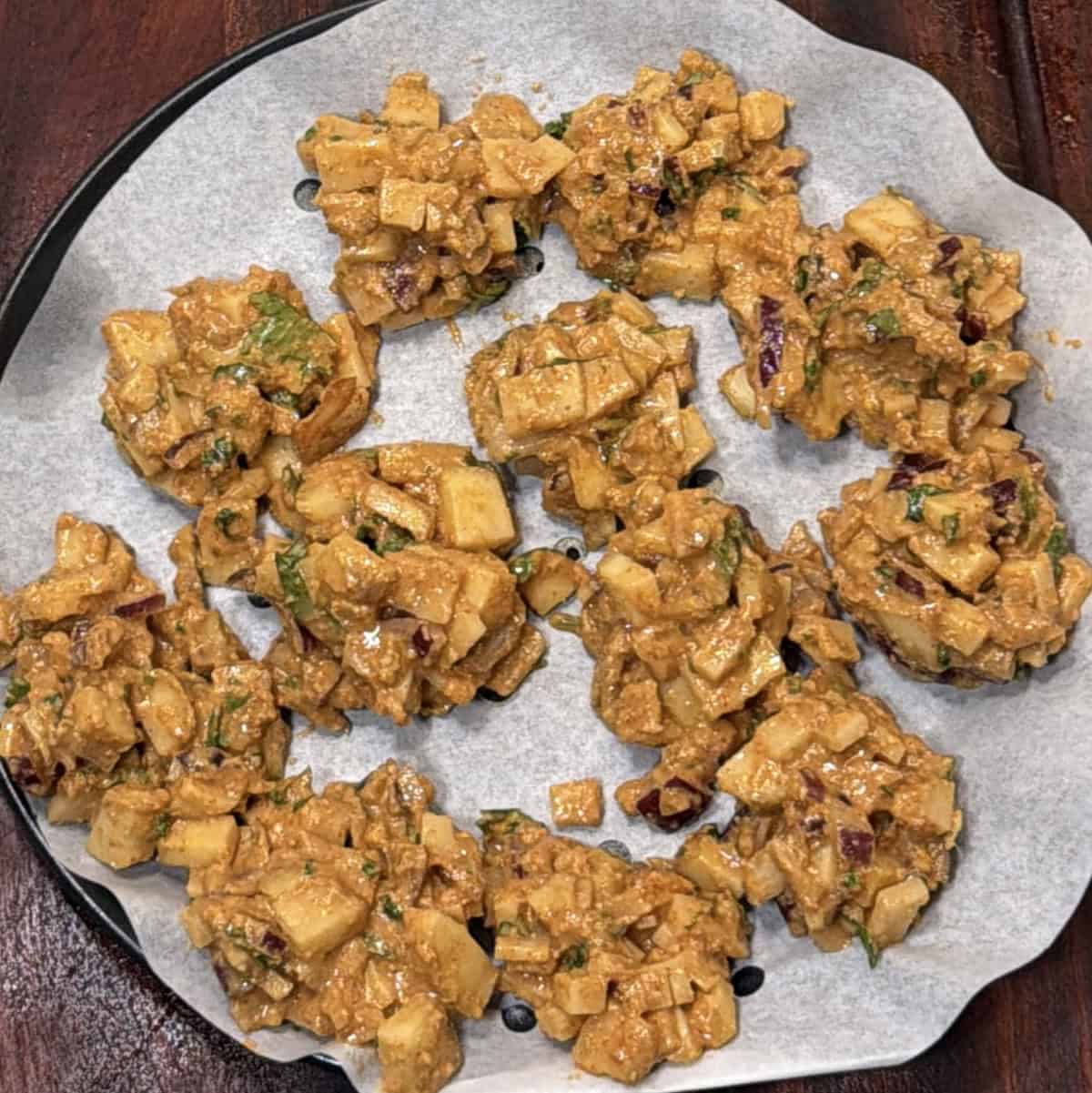 Potato pakora portions shaped on air fryer parchment paper