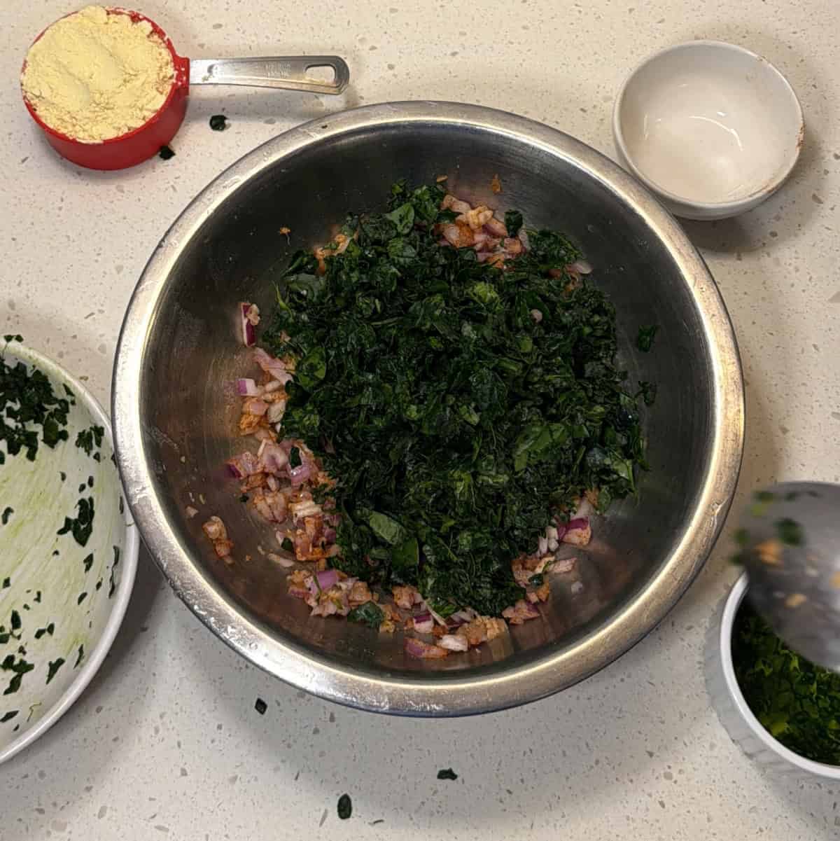 Chopped baby spinach added to onion mixture for air fryer palak pakora