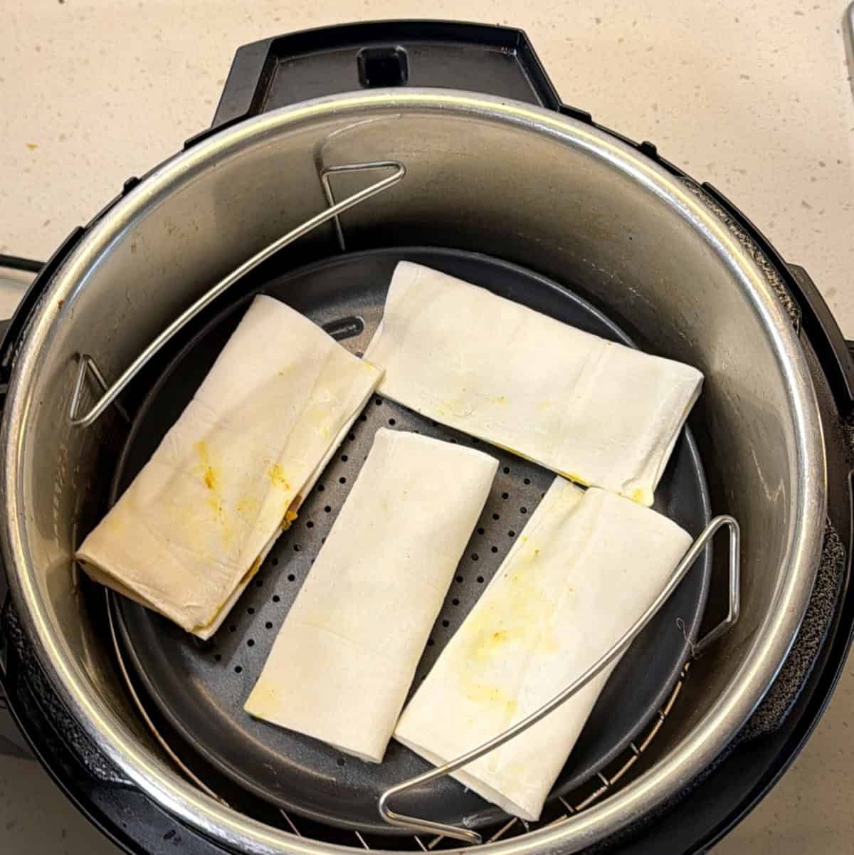 Paneer puffs placed in air fryer basket before cooking