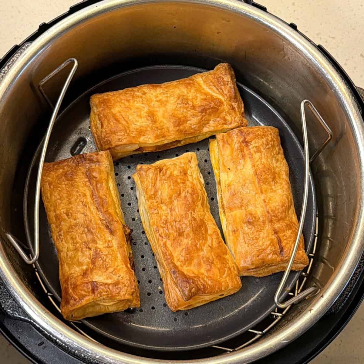 Golden brown paneer puffs cooked in air fryer basket