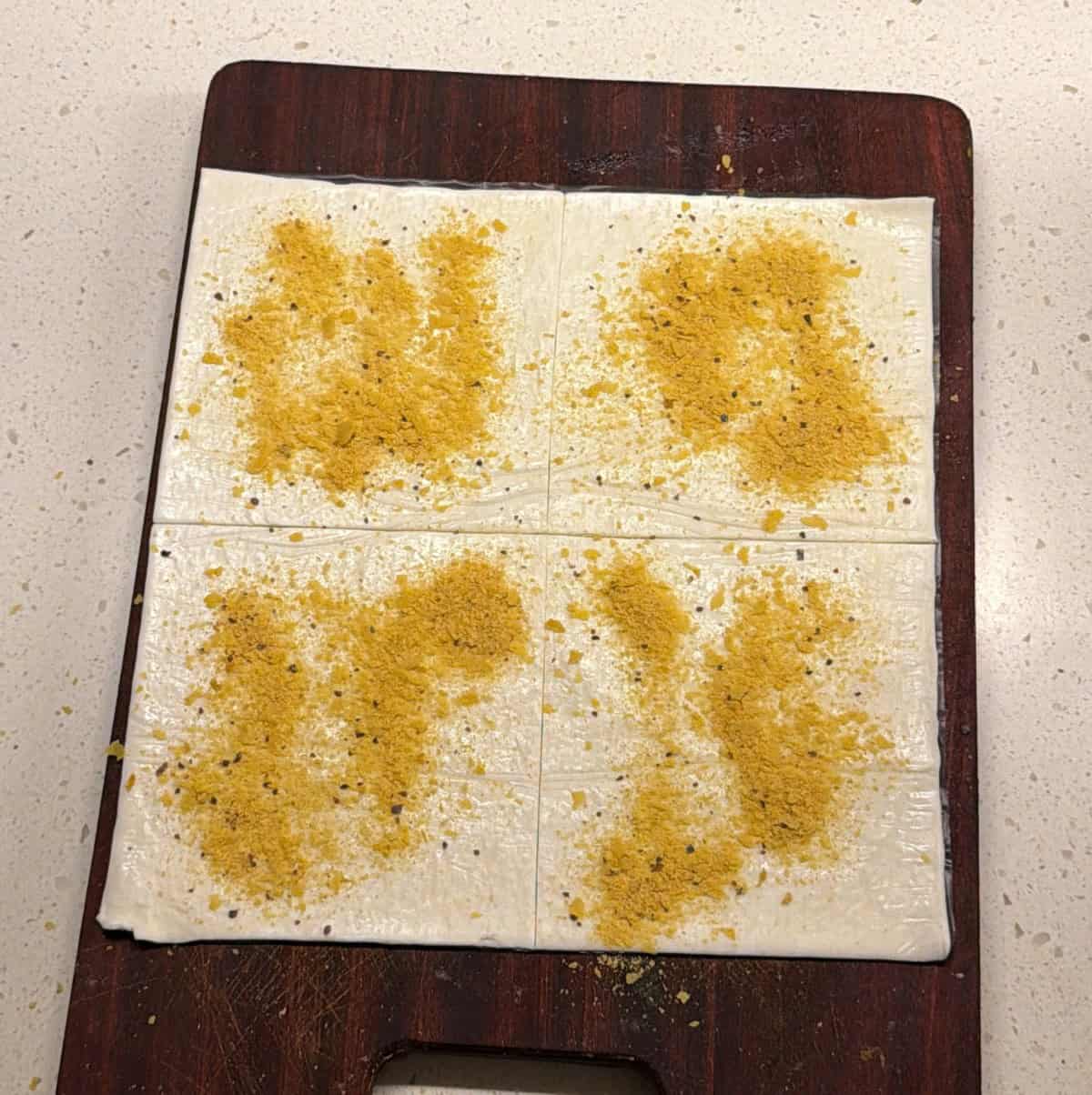 Puff pastry sheets cut into squares and topped with nutritional yeast and garlic seasoning