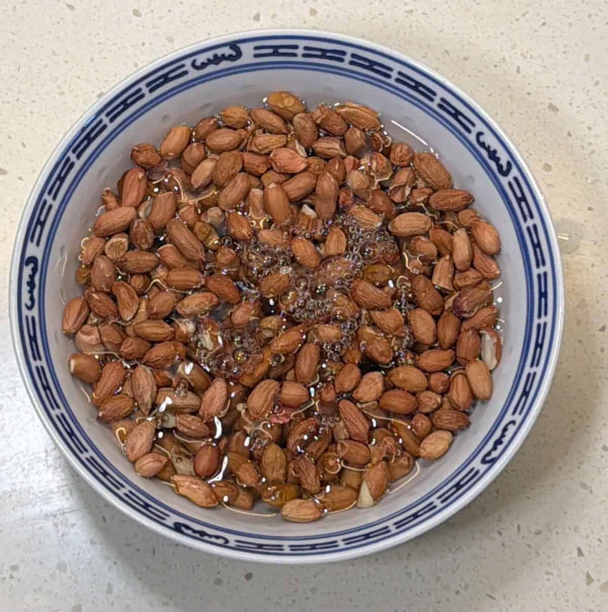 Raw peanuts soaking in water for air fryer masala peanuts
