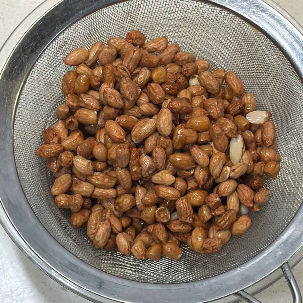Soaked peanuts draining before adding lentil flour and spices