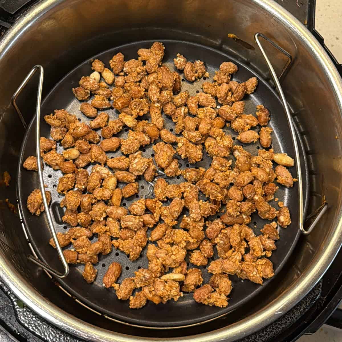 Lentil-coated masala peanuts arranged in Ninja Foodi air fryer basket