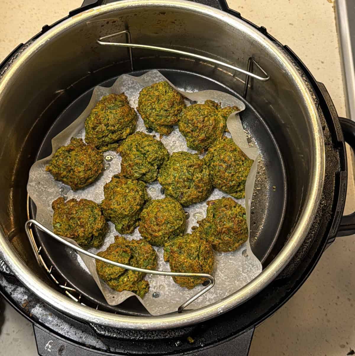 Crispy air fryer methi pakora turned and sprayed with oil