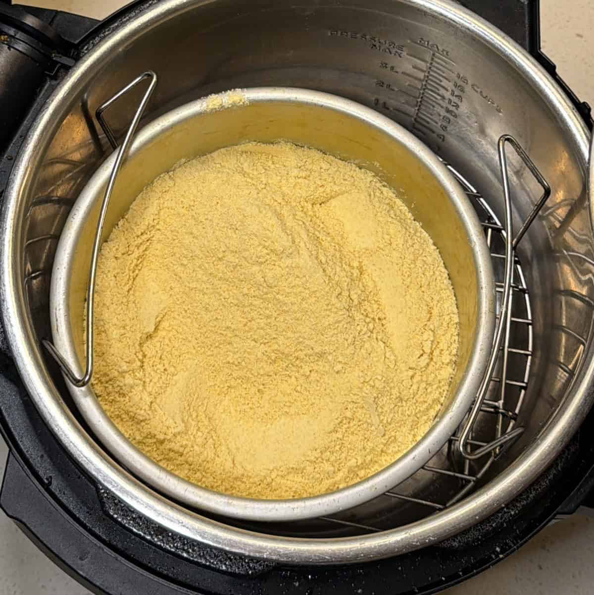 Coarse besan in metal pan for easy besan ladoo in air fryer