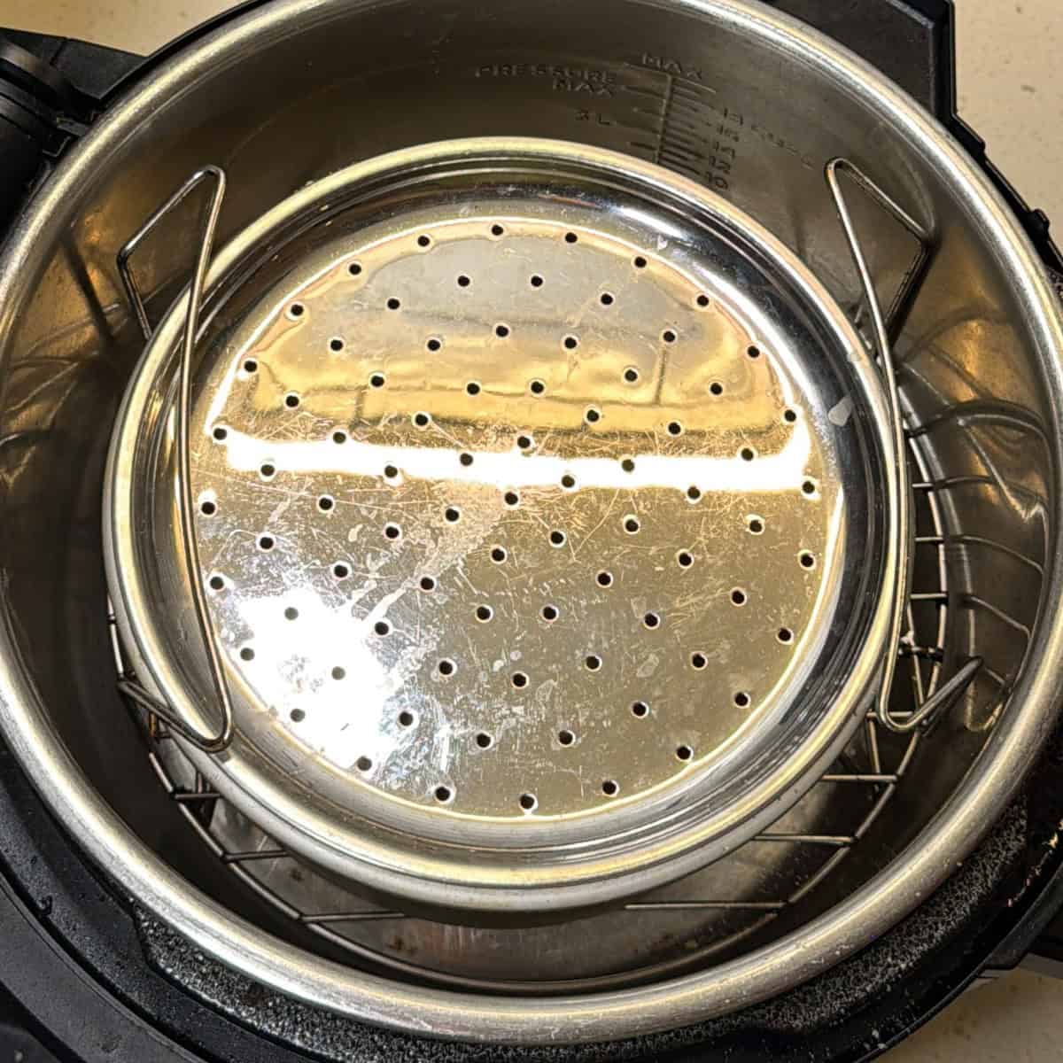 Perforated tray placed over besan while roasting in air fryer