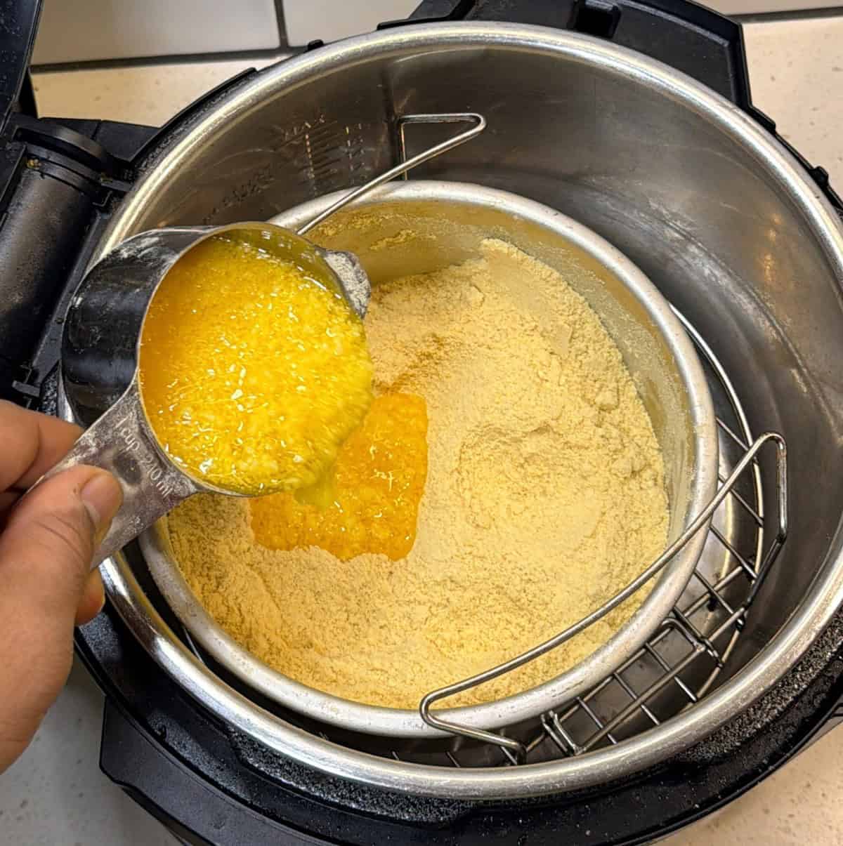 Melted ghee being added to dry roasted besan for air fryer ladoo