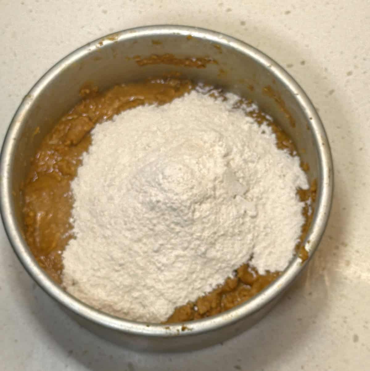 Powdered sugar added to cooled besan mixture for making ladoos