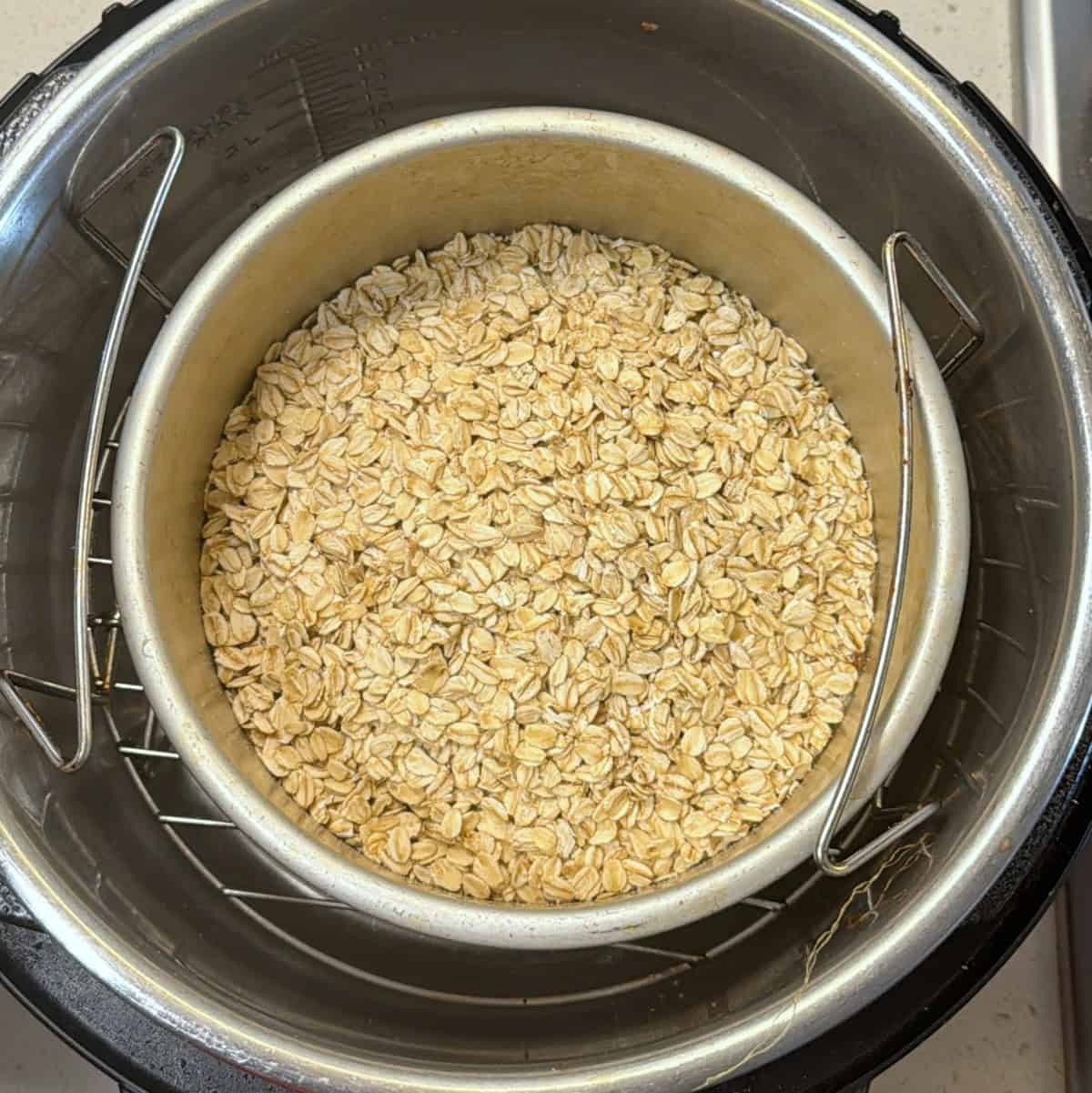 rolled oats roasting in a metal pan for air fryer oats ladoo