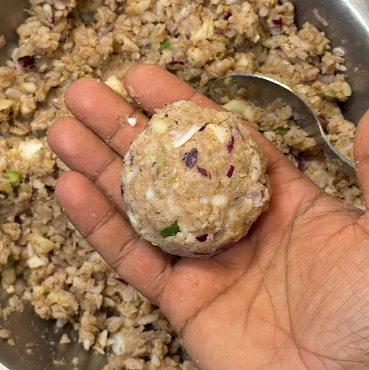 Hand shaping a poha cutlet patty before air frying