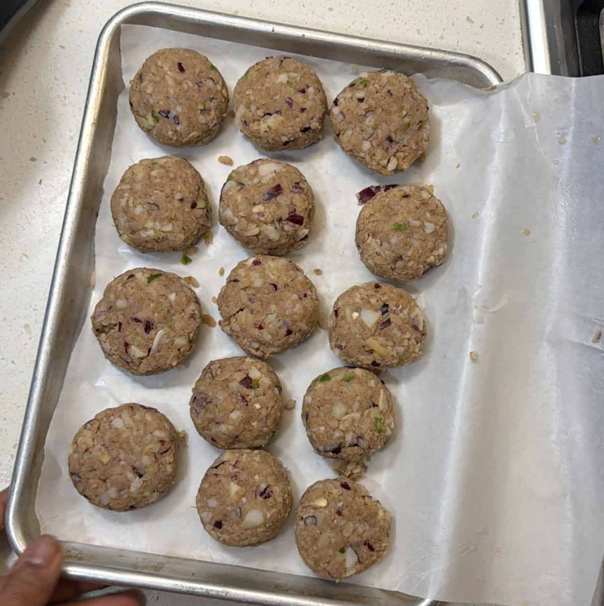 Shaped poha cutlets arranged on a tray before freezing