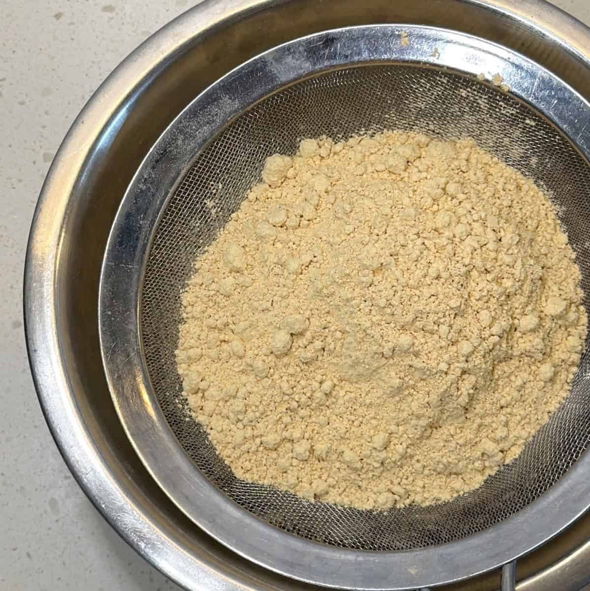 Chana sattu being sifted for sattu burfi in air fryer