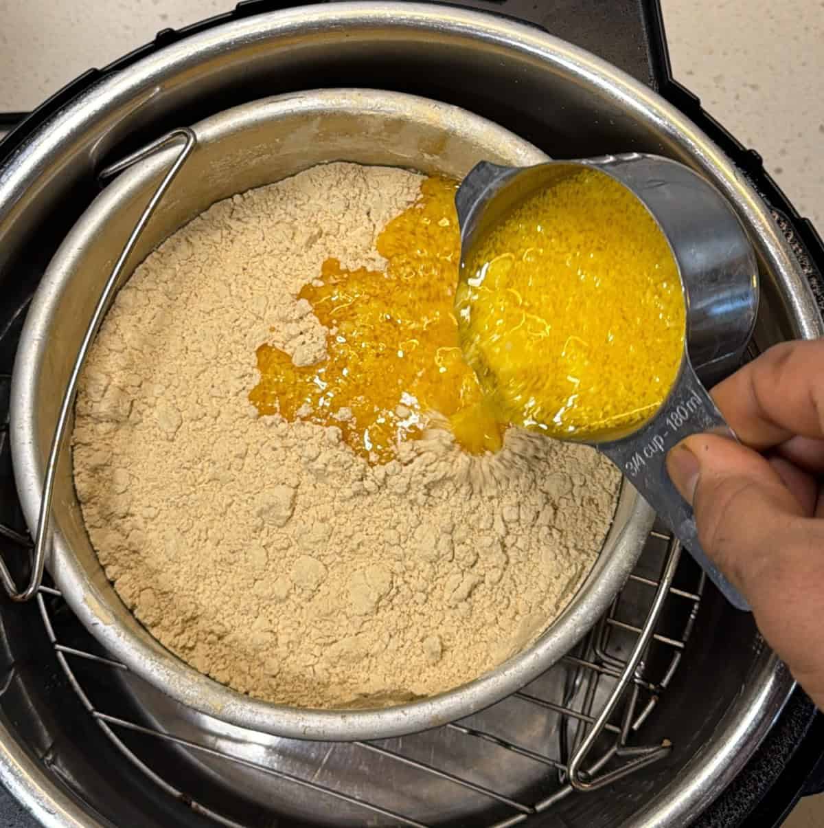Melted ghee added to dry roasted sattu for air fryer barfi