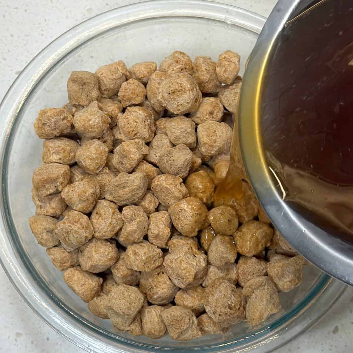 Dry soy chunks soaked in seasoned boiling water for vegan popcorn chicken