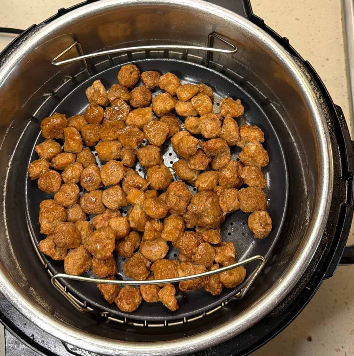 Soy chunks cooking in air fryer for vegan popcorn chicken