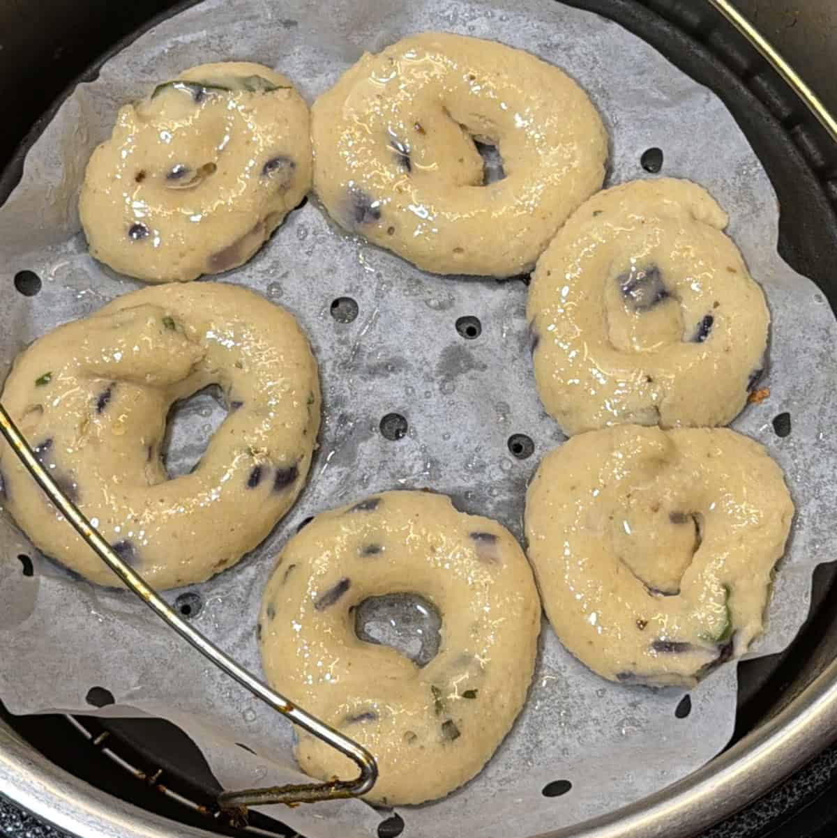 Pale steamed medu vadas in the air fryer before browning.