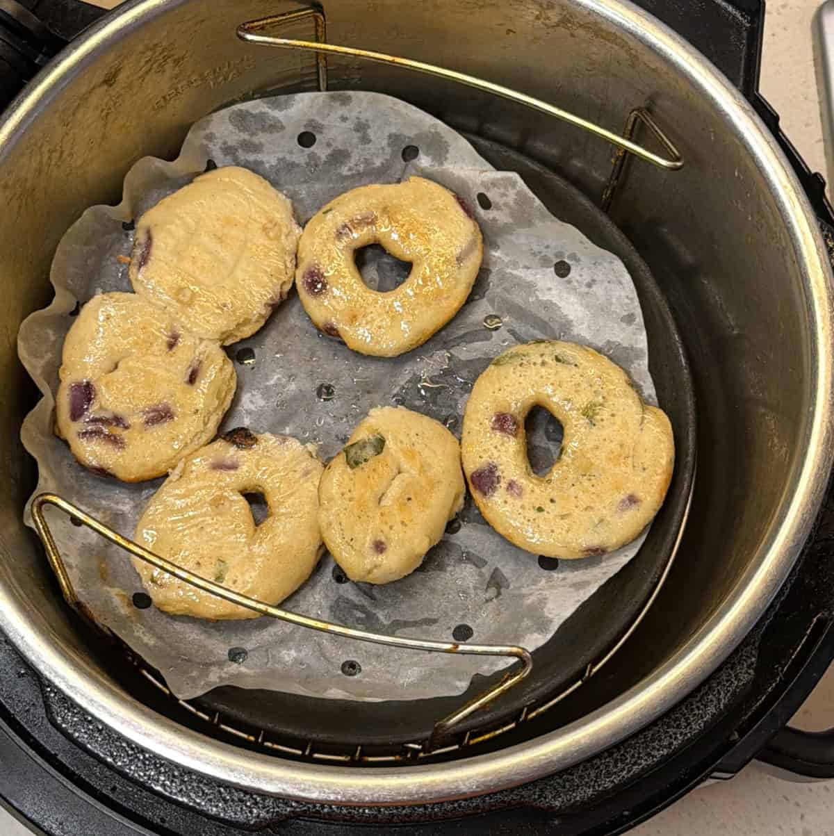 Instant medu vadas developing golden-brown colour in an air fryer.