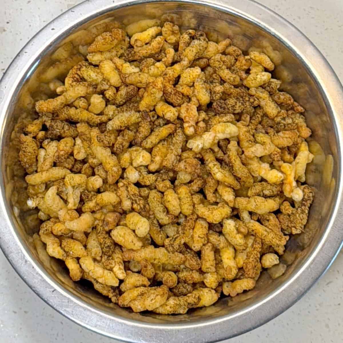 Air fried masala puffed corn cooling in a bowl