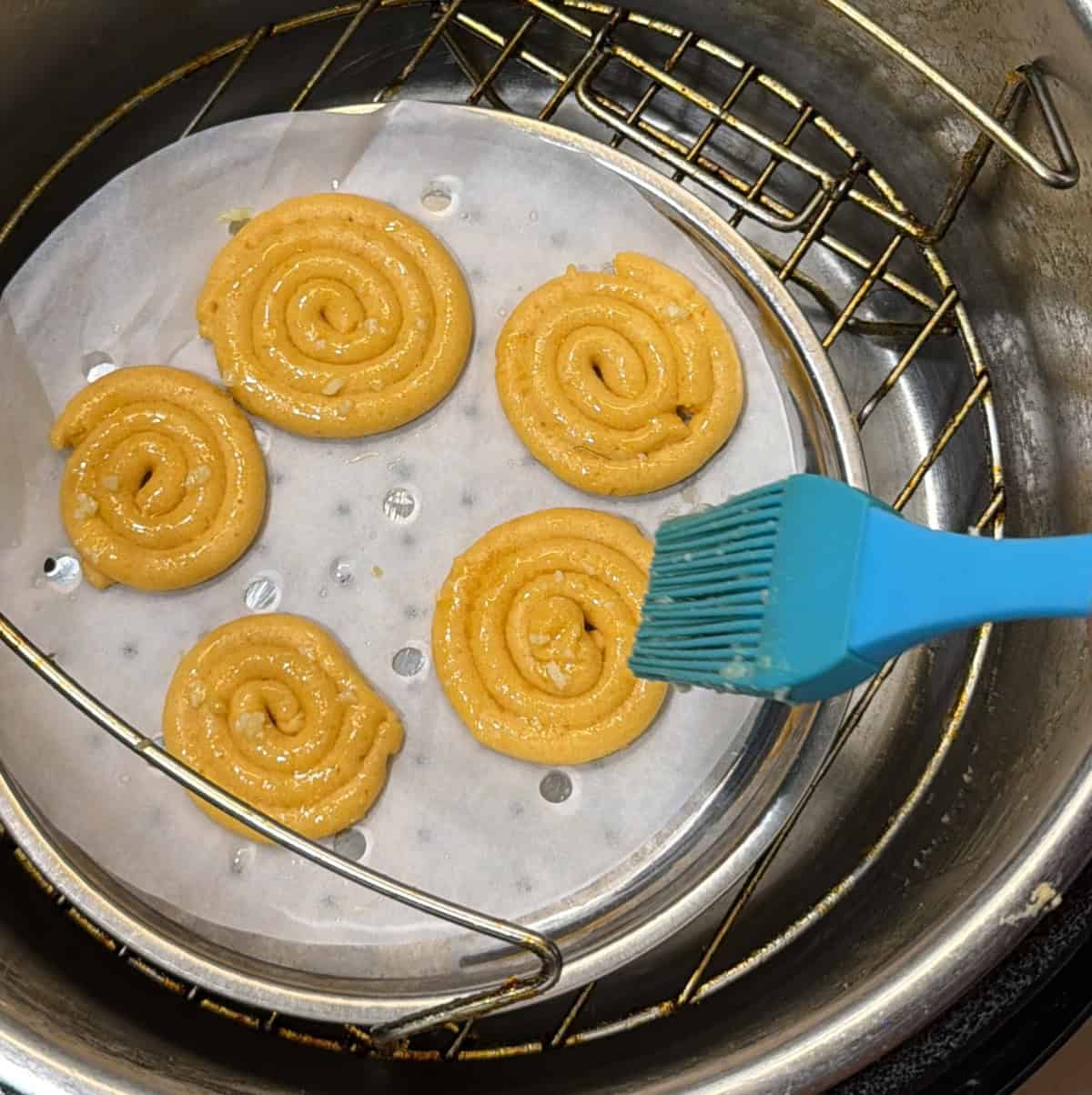 Steamed jalebi spirals brushed with ghee before air frying