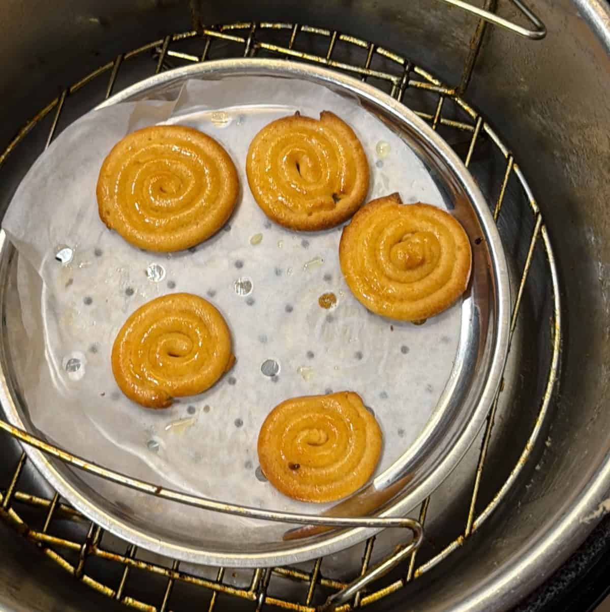 Golden jalebi finishing in the air fryer after a second flip