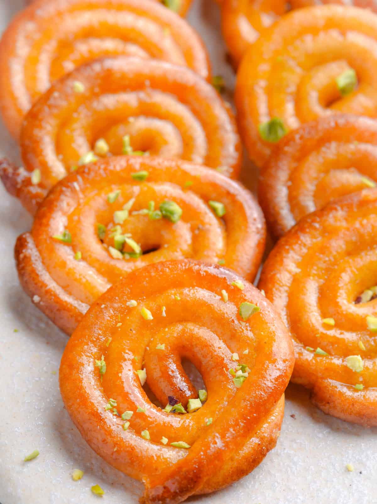 Homemade air fryer jalebi with golden spirals soaked in sugar syrup