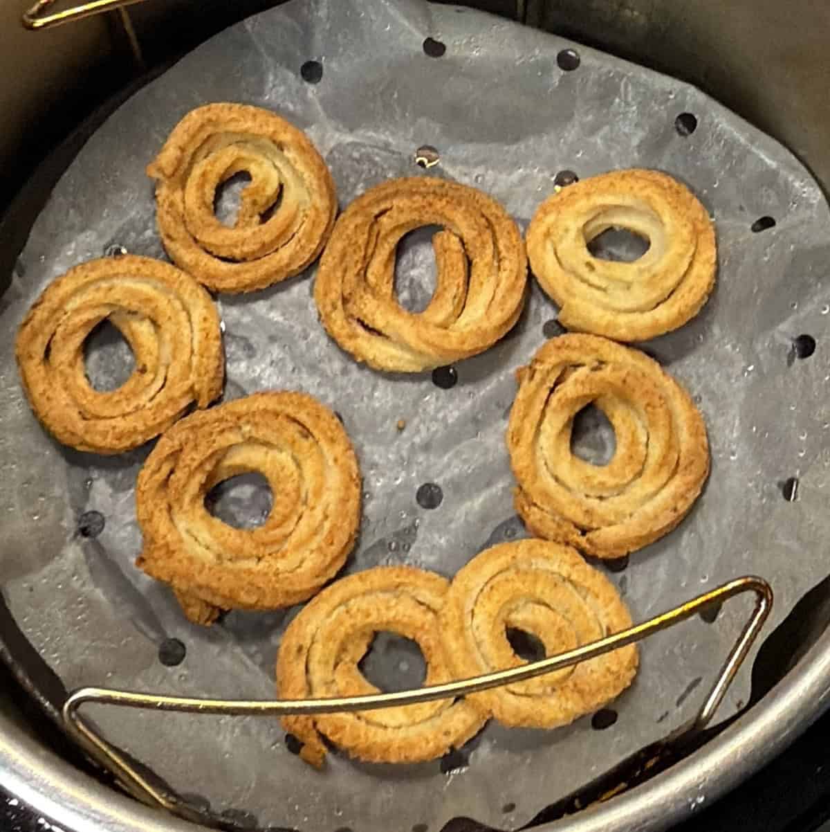 Golden brown air fryer murukku in the basket after cooking