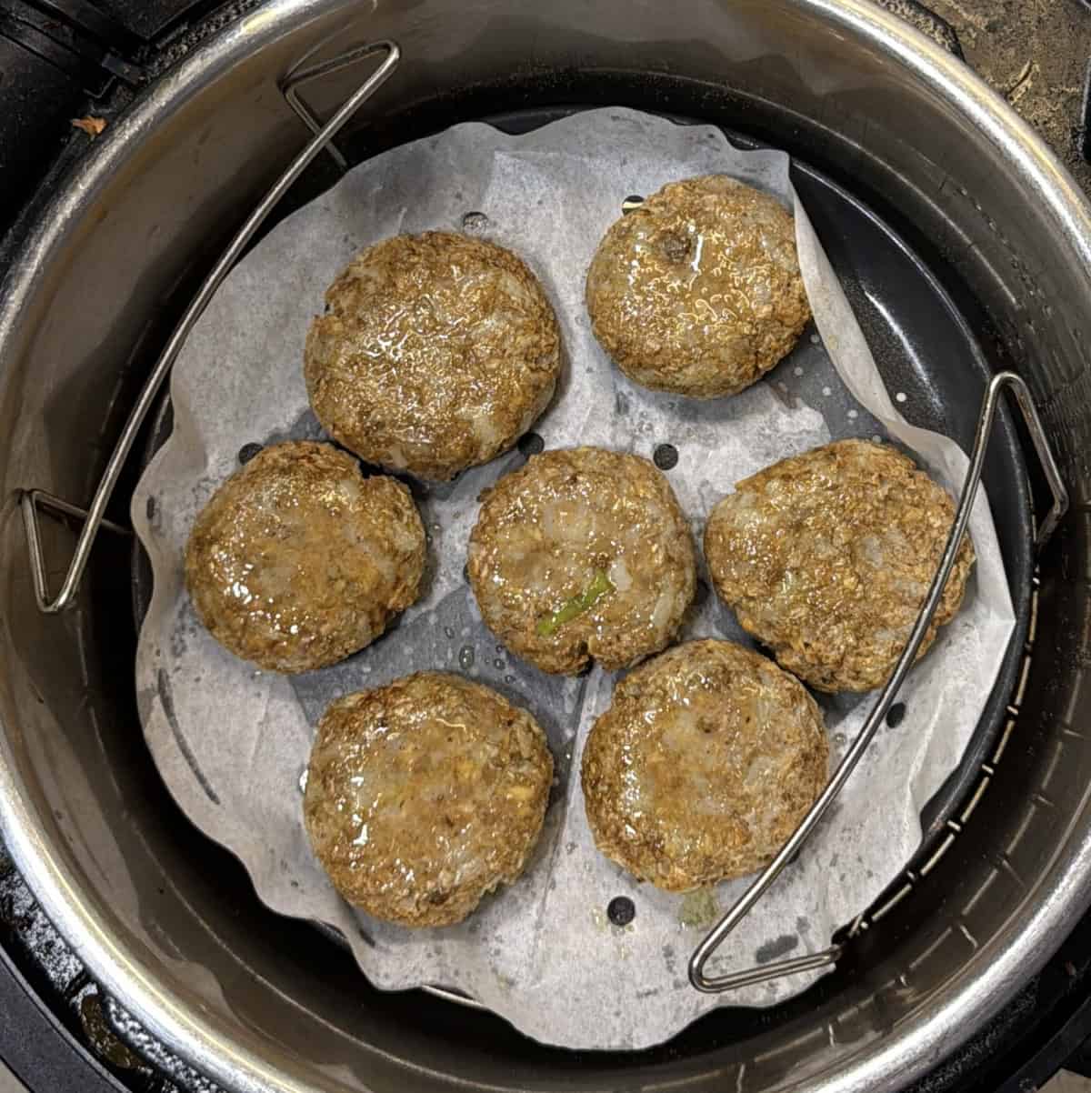 Yam cutlets arranged in an air fryer basket before cooking